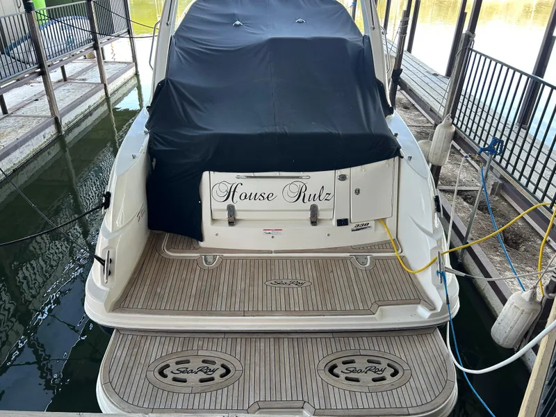 Slide: The Image of 2016 Sea Ray 330 Sundancer docked, covered, with "House Rulz" on the stern. - 6