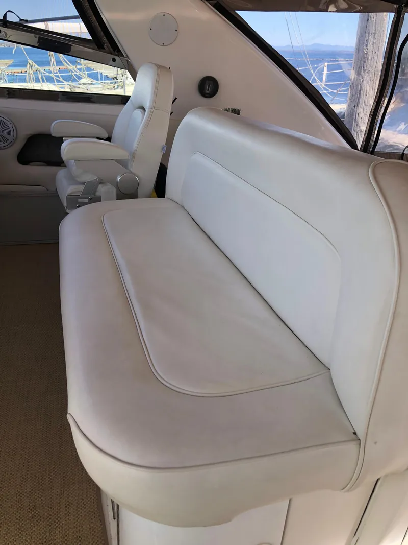 Slide: The Image of 1995 Sea Ray 450 Sundancer interior with white leather seating and scenic window view. - 25
