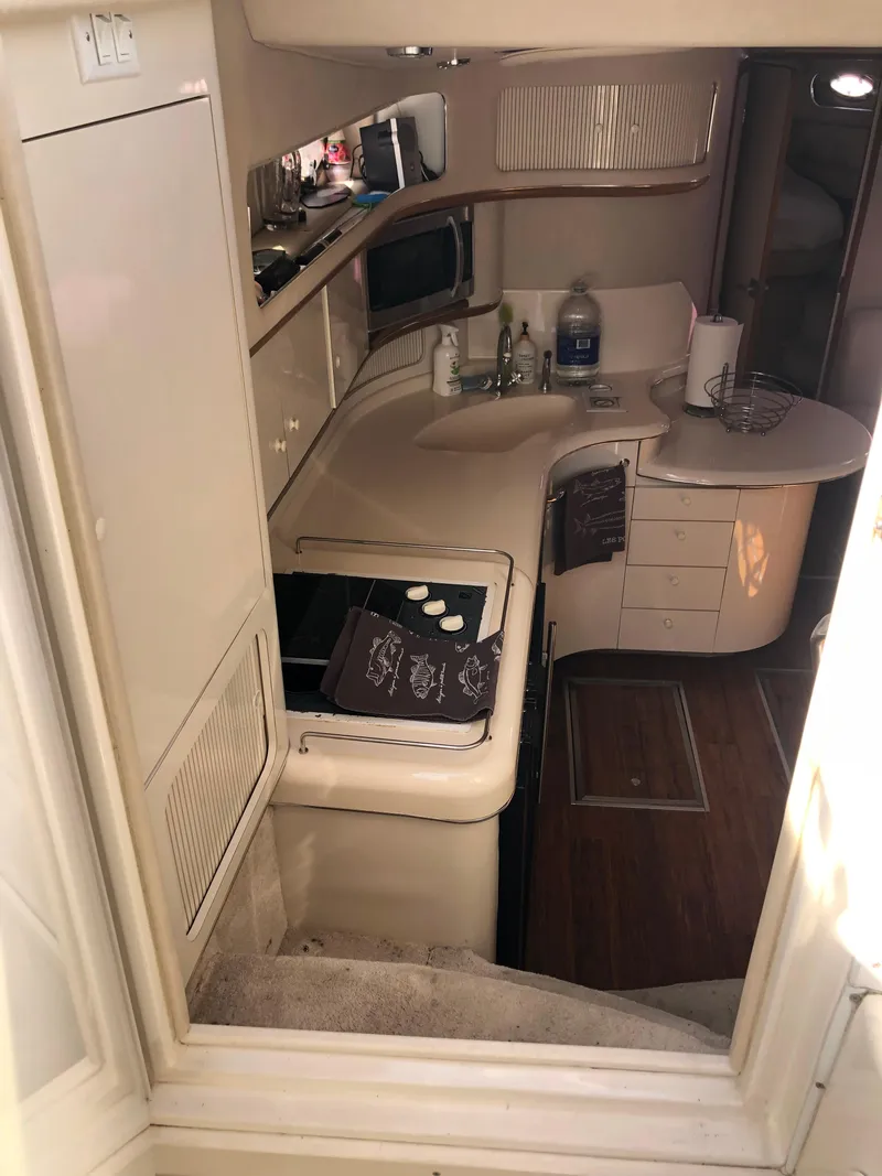 Slide: The Image of Interior of 1995 Sea Ray 450 Sundancer yacht with compact kitchen area. - 26