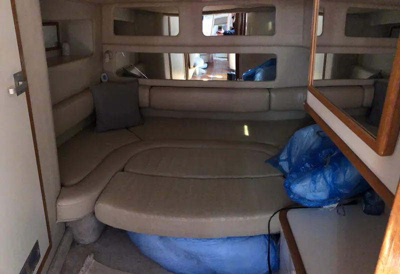 Slide: The Image of Interior cabin of 1995 Sea Ray 450 Sundancer yacht with beige seating and blue bags. - 29