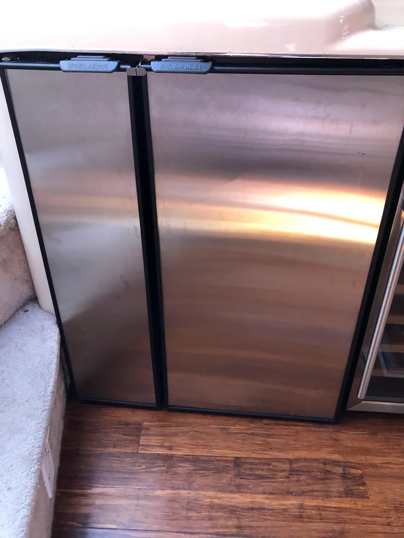 Slide: The Image of Stainless steel refrigerator on 1995 Sea Ray 450 Sundancer yacht, wooden floor visible. - 31