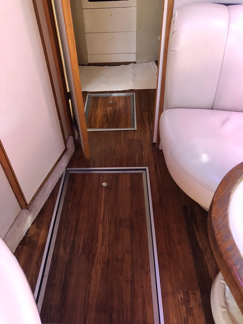 Slide: The Image of Interior of 1995 Sea Ray 450 Sundancer with wood flooring and white seating. - 38