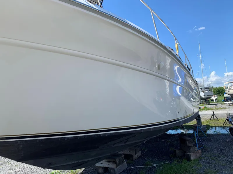 Slide: The Image of 1995 Sea Ray 450 Sundancer yacht on dry dock under clear blue sky. - 7