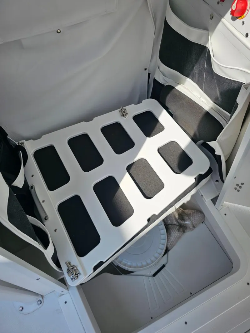 Slide: The Image of 2025 Wellcraft 223 Fisherman boat storage compartment with secure hatch and organized interior. - 12