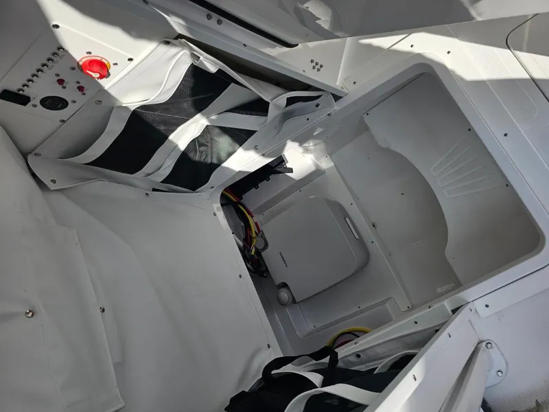 Slide: The Image of Interior view of 2025 Wellcraft 223 Fisherman boat, showcasing storage compartments and control panel. - 13