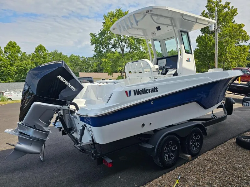 Slide: The Image of 2025 Wellcraft 223 Fisherman boat with Mercury engine on trailer, parked outdoors. - 4