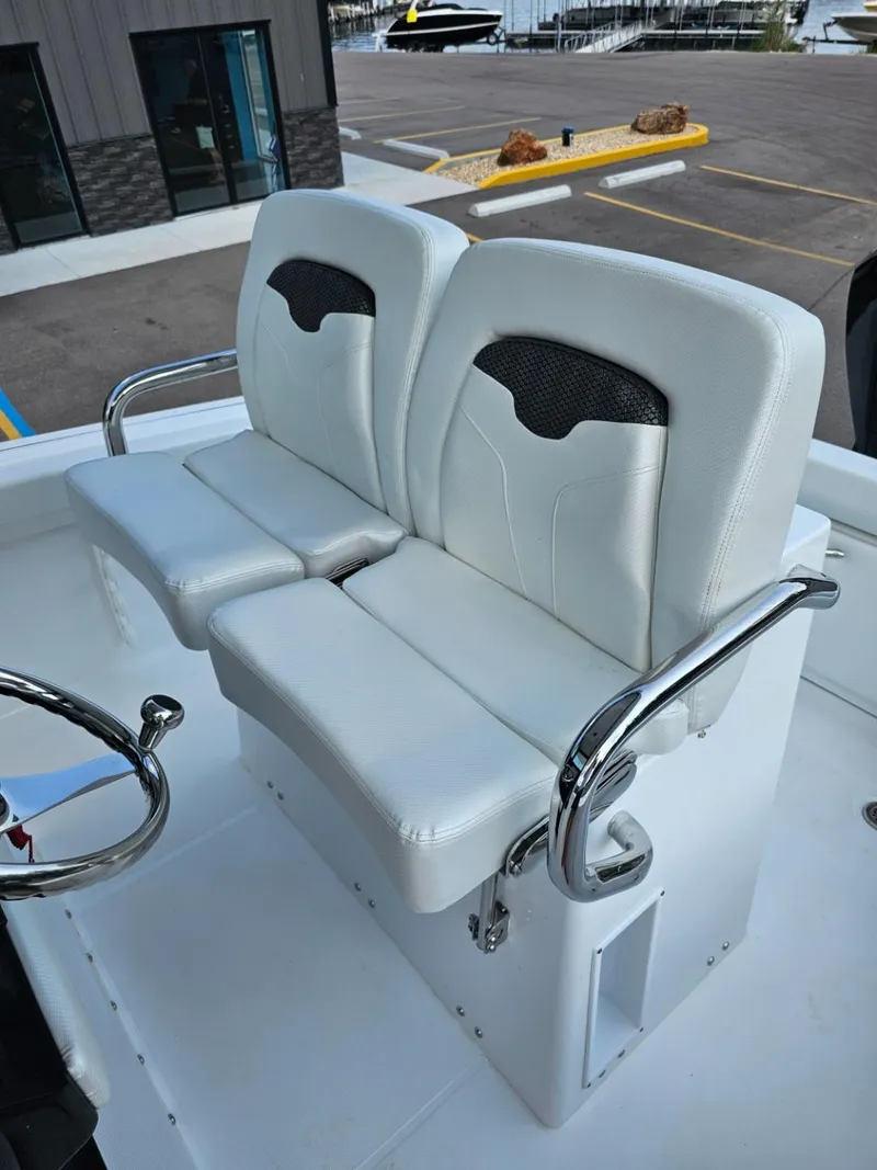 Slide: The Image of 2025 Wellcraft 243 Fisherman boat with dual white cushioned seats and chrome armrests. - 10