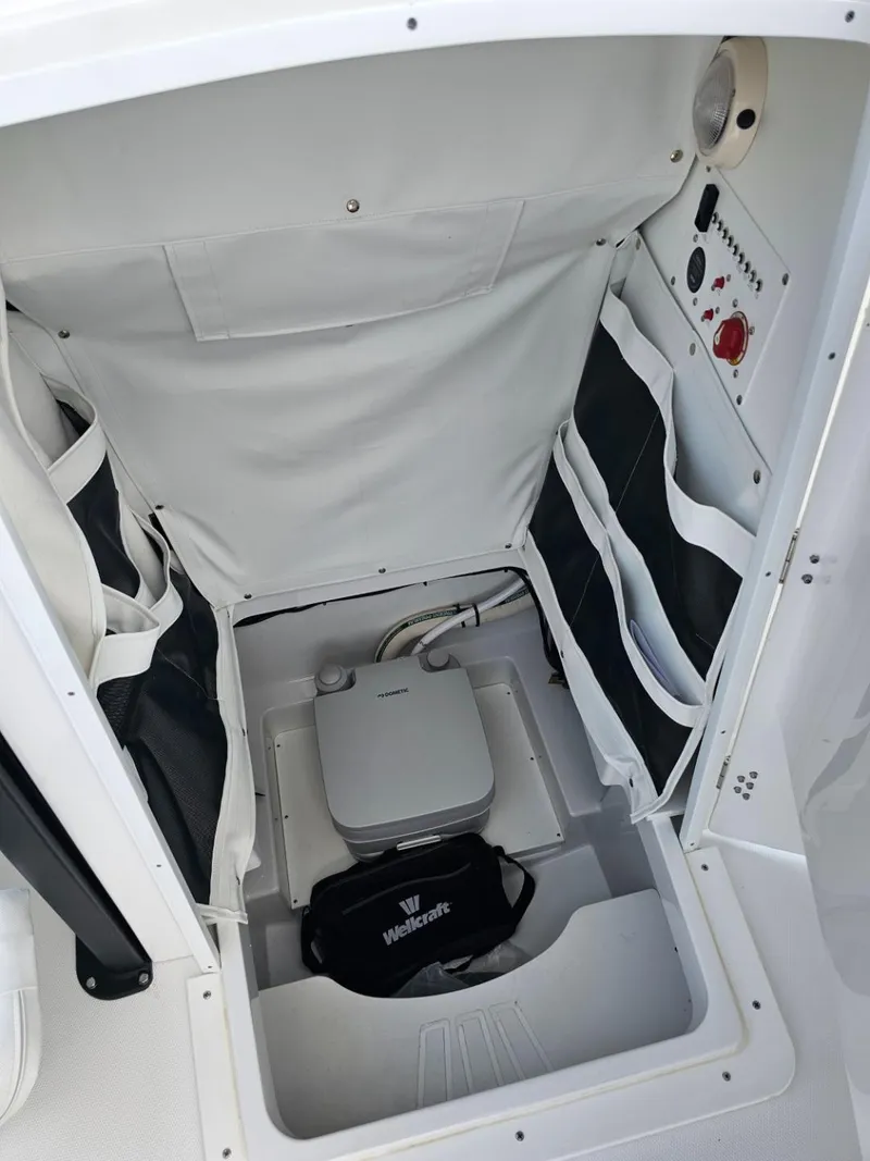 Slide: The Image of 2025 Wellcraft 243 Fisherman boat interior storage compartment with portable toilet. - 15