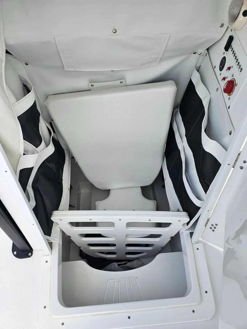Slide: The Image of 2025 Wellcraft 243 Fisherman boat storage compartment with organized gear and control panel. - 16