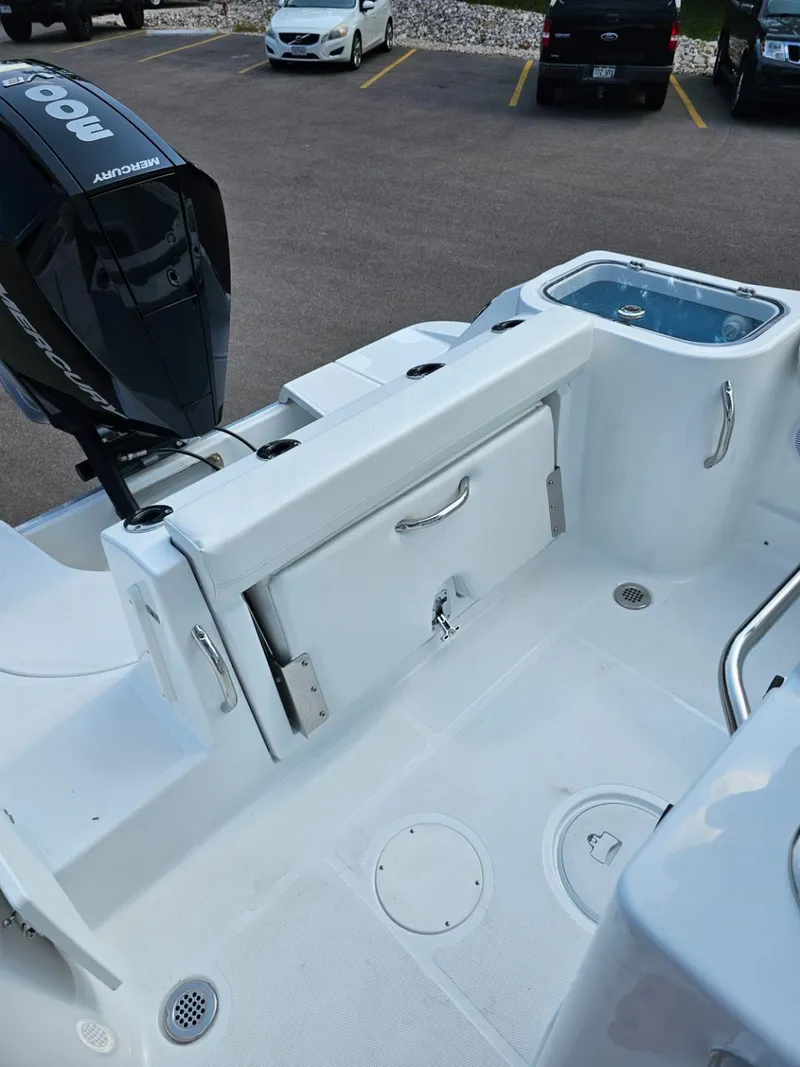 Slide: The Image of 2025 Wellcraft 243 Fisherman boat deck with storage compartments and outboard motor. - 17