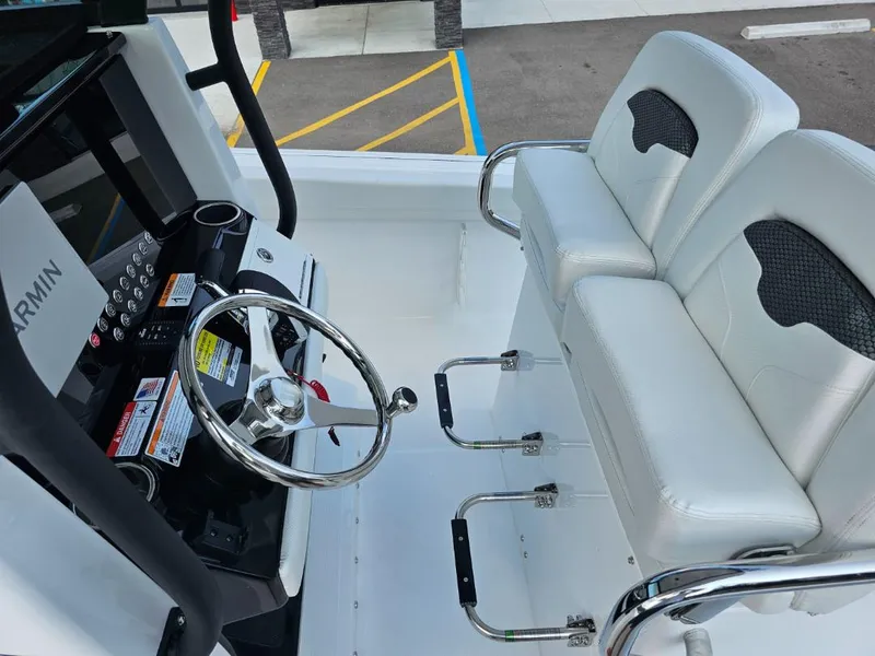 Slide: The Image of 2025 Wellcraft 243 Fisherman boat interior with steering wheel and white seating. - 9