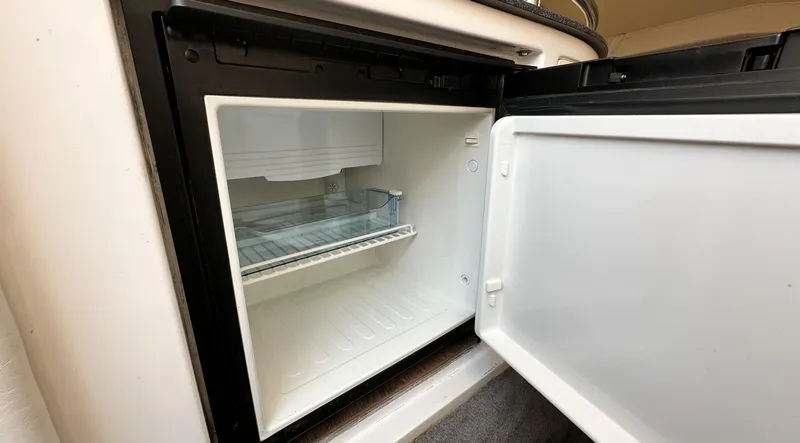 Slide: The Image of Open refrigerator inside a 2007 Fountain 47 Lightning boat, showing empty interior. - 28
