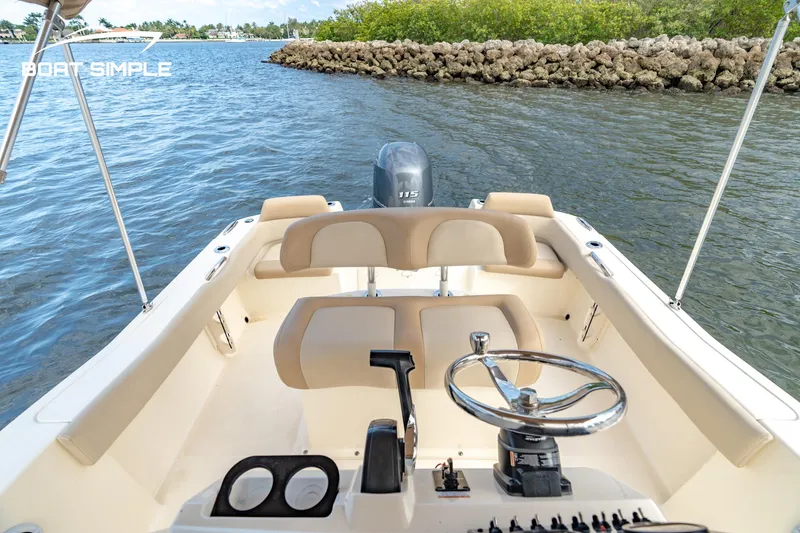 Slide: The Image of 2021 Scout 195 Sportfish boat interior with steering wheel and controls on water. - 12