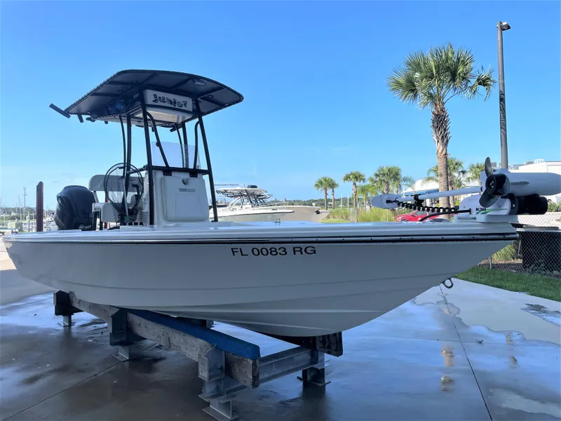 Slide: The Image of 2017 Pathfinder 2300 HPS boat on a lift with palm trees in the background. - 2