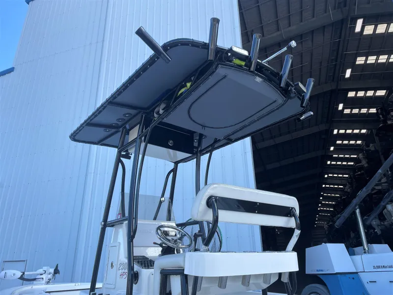 Slide: The Image of 2017 Pathfinder 2300 HPS boat with T-top and rod holders in a storage facility. - 21