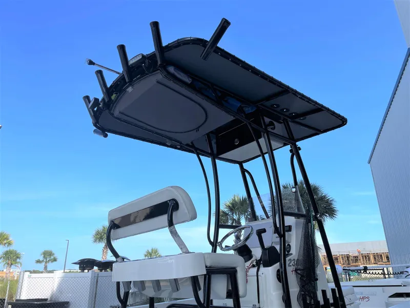 Slide: The Image of 2017 Pathfinder 2300 HPS boat with T-top and seating, docked under clear blue sky. - 22