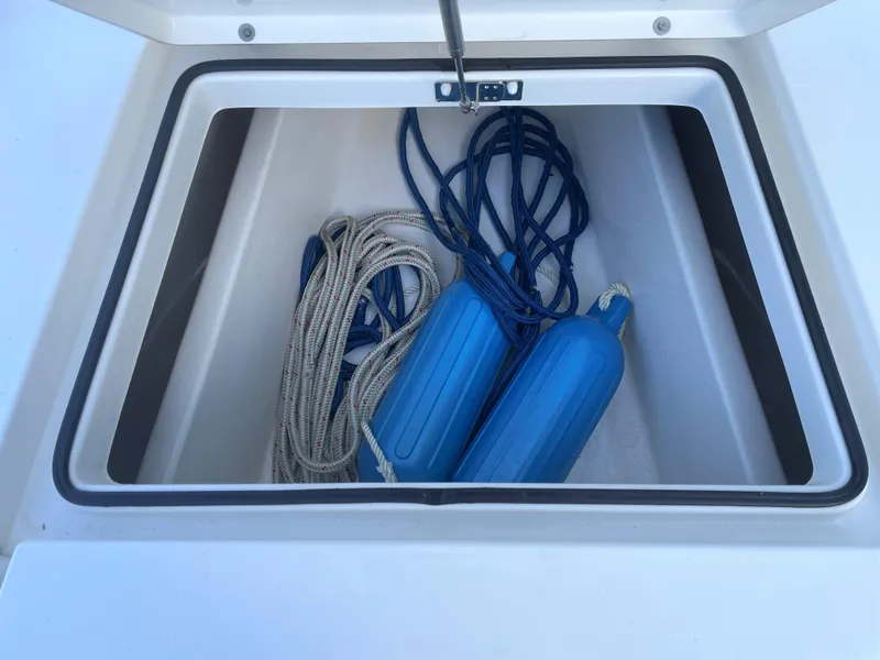 Slide: The Image of Storage compartment of a 2017 Pathfinder 2300 HPS boat with ropes and blue fenders. - 28