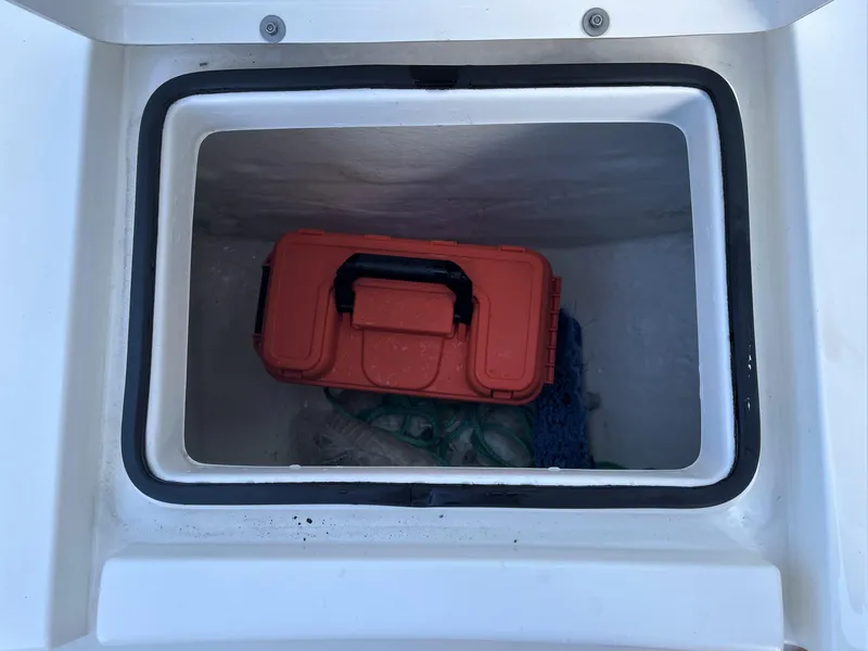 Slide: The Image of Storage compartment of a 2017 Pathfinder 2300 HPS boat with an orange toolbox. - 29