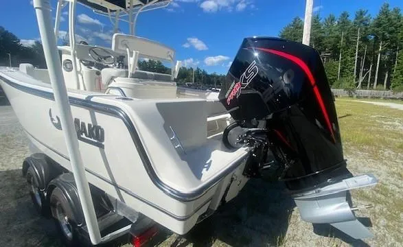 Slide: The Image of 2024 Mako 214 CC boat with powerful outboard motor, parked outdoors. - 2