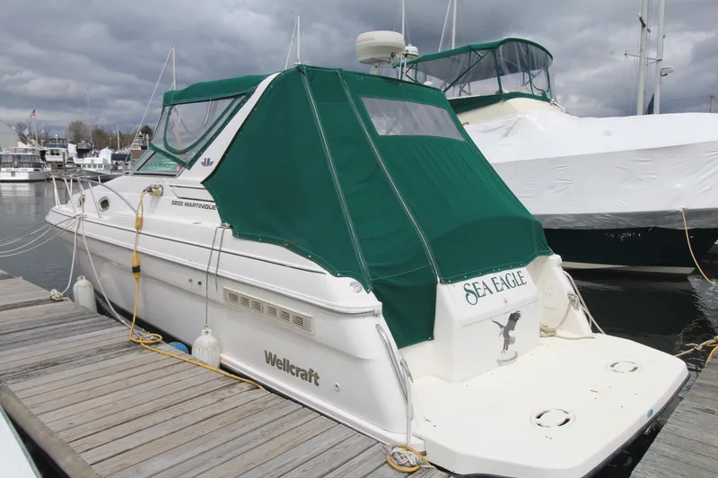 The Image of 1998 Wellcraft 3200 Martinique boat docked with green canopy, named "Sea Eagle." - 0
