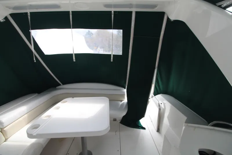 Slide: The Image of 1998 Wellcraft 3200 Martinique boat interior with seating and table, green canopy. - 13