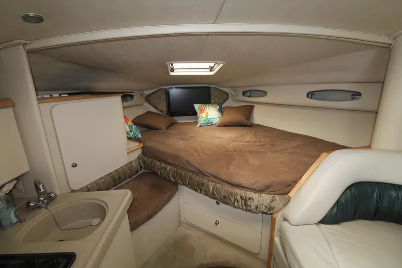 Slide: The Image of 1998 Wellcraft 3200 Martinique cabin interior with bed, sink, and cozy decor. - 18