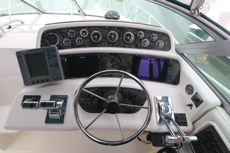 Slide: The Image of 1998 Wellcraft 3200 Martinique boat dashboard with steering wheel and navigation instruments. - 2