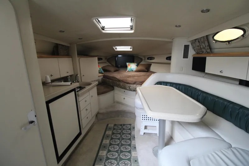Slide: The Image of 1998 Wellcraft 3200 Martinique cabin interior with kitchenette, dining area, and sleeping quarters. - 20