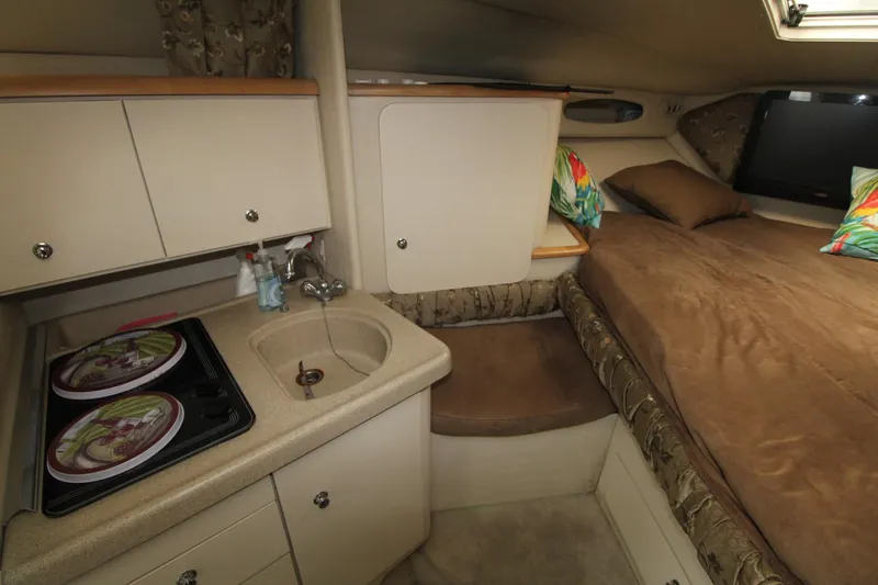 Slide: The Image of 1998 Wellcraft 3200 Martinique cabin interior with kitchenette and cozy sleeping area. - 23