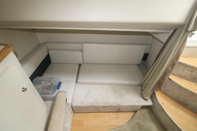 Slide: The Image of 1998 Wellcraft 3200 Martinique cabin interior with white seating and wooden flooring. - 24