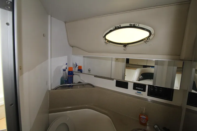 Slide: The Image of 1998 Wellcraft 3200 Martinique bathroom with porthole, mirror, and toiletries. - 27