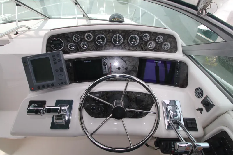 Slide: The Image of 1998 Wellcraft 3200 Martinique helm with steering wheel, gauges, and navigation equipment. - 3