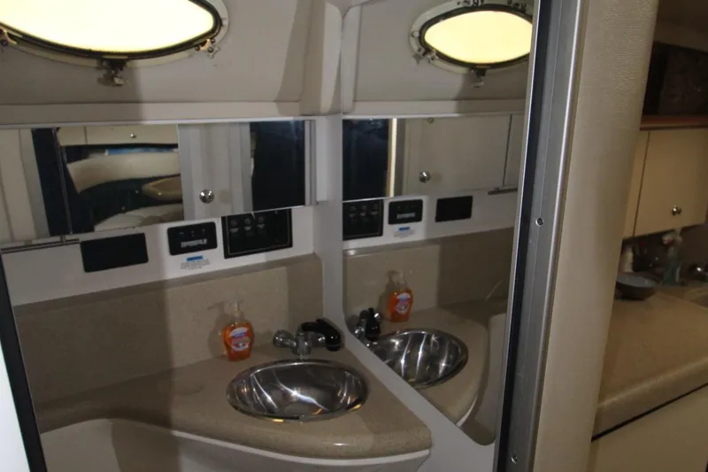 Slide: The Image of 1998 Wellcraft 3200 Martinique bathroom with dual sinks and mirrors. - 32