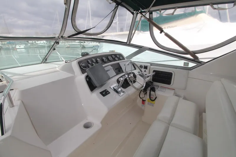 Slide: The Image of 1998 Wellcraft 3200 Martinique boat cockpit with steering wheel and control panel. - 5