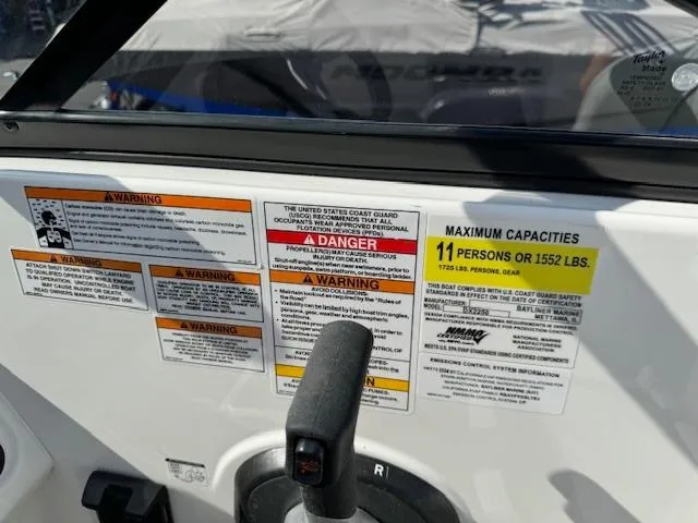 Slide: The Image of 2024 Bayliner DX 2250 boat dashboard with safety warnings and maximum capacity label. - 13