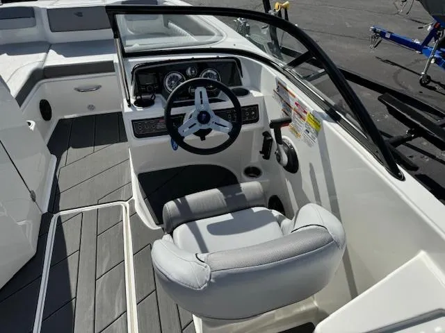 Slide: The Image of 2024 Bayliner DX 2250 boat cockpit with steering wheel and captain's chair. - 6