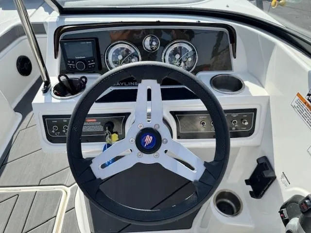 Slide: The Image of 2024 Bayliner DX 2250 boat dashboard with steering wheel and instrument panel. - 7