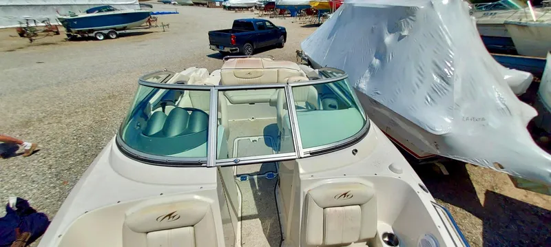 Slide: The Image of 2006 Monterey 234 FS boat with green seats and open bow, parked in a marina. - 14