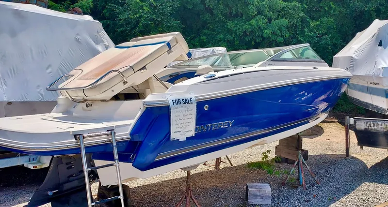 Slide: The Image of 2006 Monterey 234 FS boat for sale, blue and white, parked on a trailer. - 3