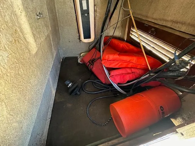 Slide: The Image of Storage compartment of a 1987 Boston Whaler 17 Montauk with life jackets and safety equipment. - 17