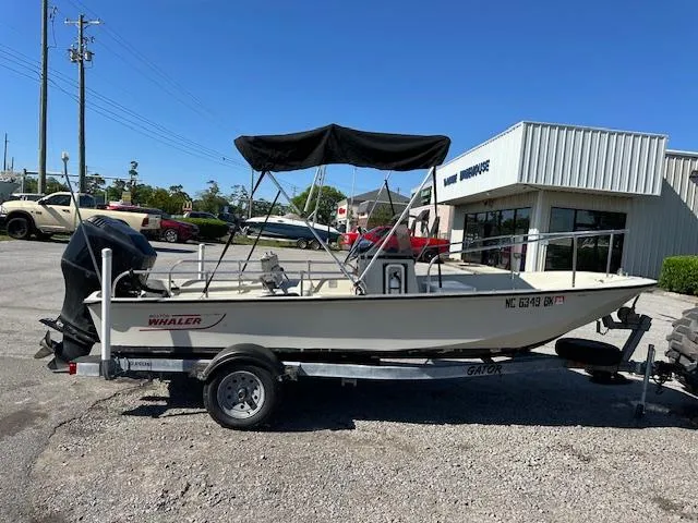 Slide: The Image of 1987 Boston Whaler 17 Montauk boat on a trailer in a parking lot. - 2