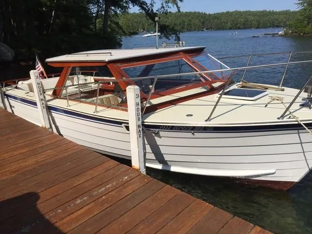 Slide: The Image of 1986 Skiff Craft Sport Fisherman 260 docked by a wooden pier on a lake. - 0