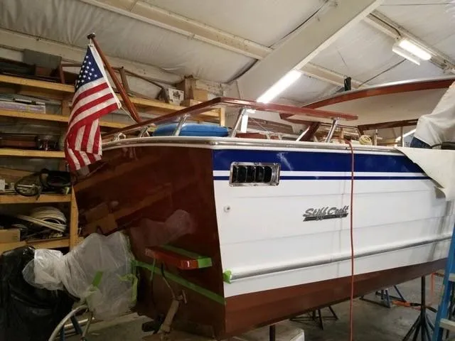Slide: The Image of 1986 Skiff Craft Sport Fisherman 260 in a workshop with American flag. - 5