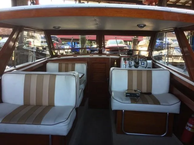 Slide: The Image of 1986 Skiff Craft Sport Fisherman 260 interior with striped seating and wooden accents. - 6