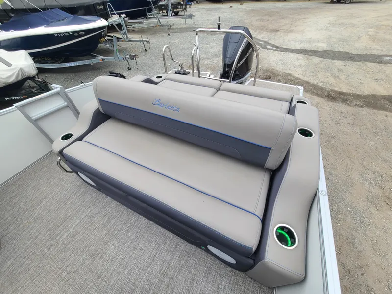 Slide: The Image of 2022 Barletta CORSA 25UC boat with rear seating and motor, docked on gravel. - 24