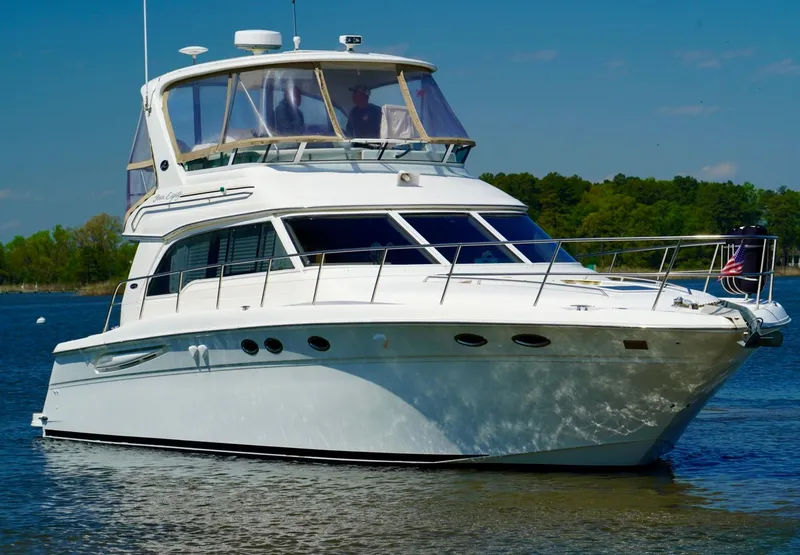 Slide: The Image of 2002 Sea Ray 480 Sedan Bridge yacht on calm water. - 2