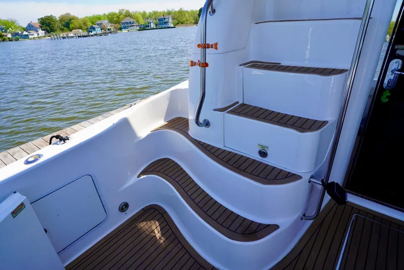 Slide: The Image of 2002 Sea Ray 480 Sedan Bridge boat steps and deck by the water - 25