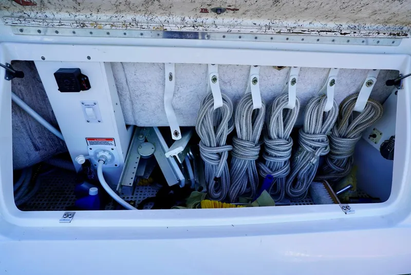 Slide: The Image of Storage compartment on a 2002 Sea Ray 480 Sedan Bridge with coiled ropes and equipment. - 27