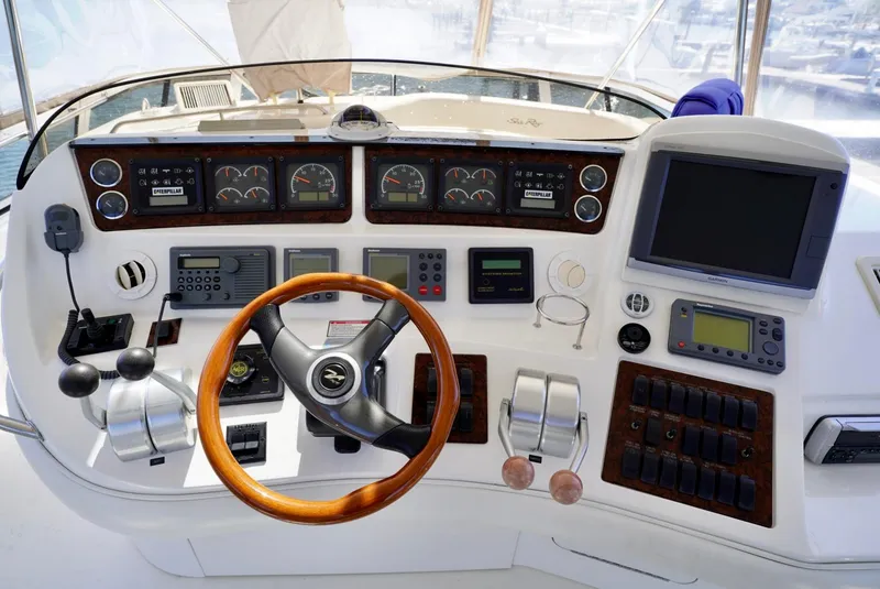 Slide: The Image of 2002 Sea Ray 480 Sedan Bridge helm with navigation instruments and wooden steering wheel. - 33