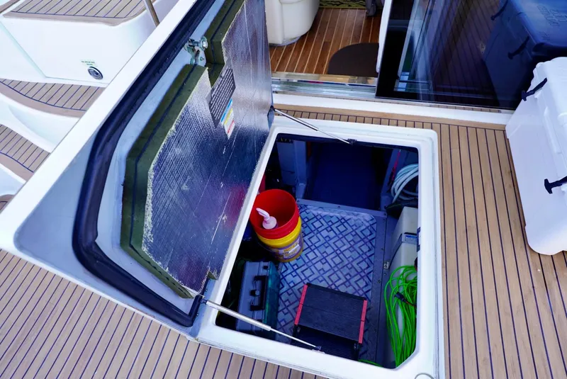 Slide: The Image of Open hatch on 2002 Sea Ray 480 Sedan Bridge showing storage area with equipment. - 45